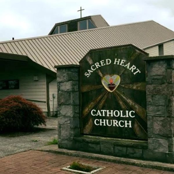 Sign for Sacred Heart Catholic Church outside the building.