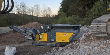 Kleiner mobiler Steinbrecher auf einer Baustelle.