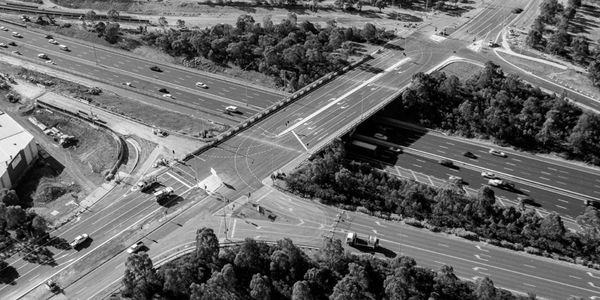 Aerial view of a busy highway intersection with multiple lanes and vehicles.