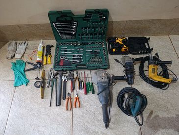 A variety of hand and power tools neatly arranged on the floor.