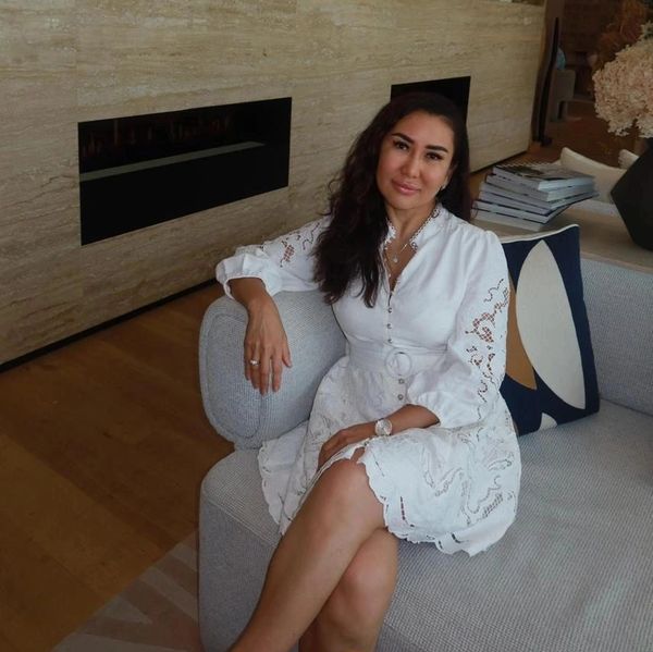 Woman in a white dress sitting on a sofa.