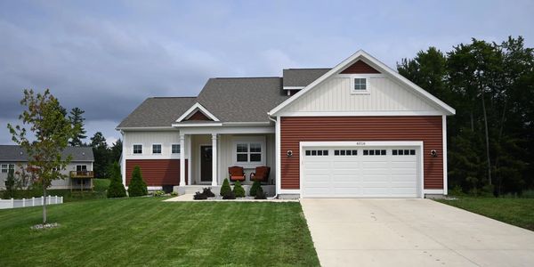 Modern suburban house with a green lawn and driveway.
