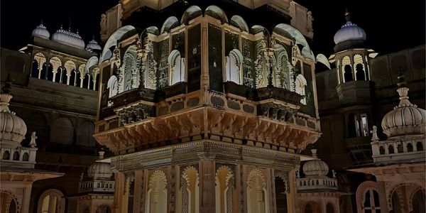 Intricately carved historic building illuminated at night.