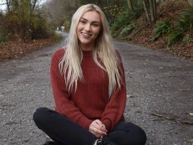 Shot of a lady sitting on the pavement