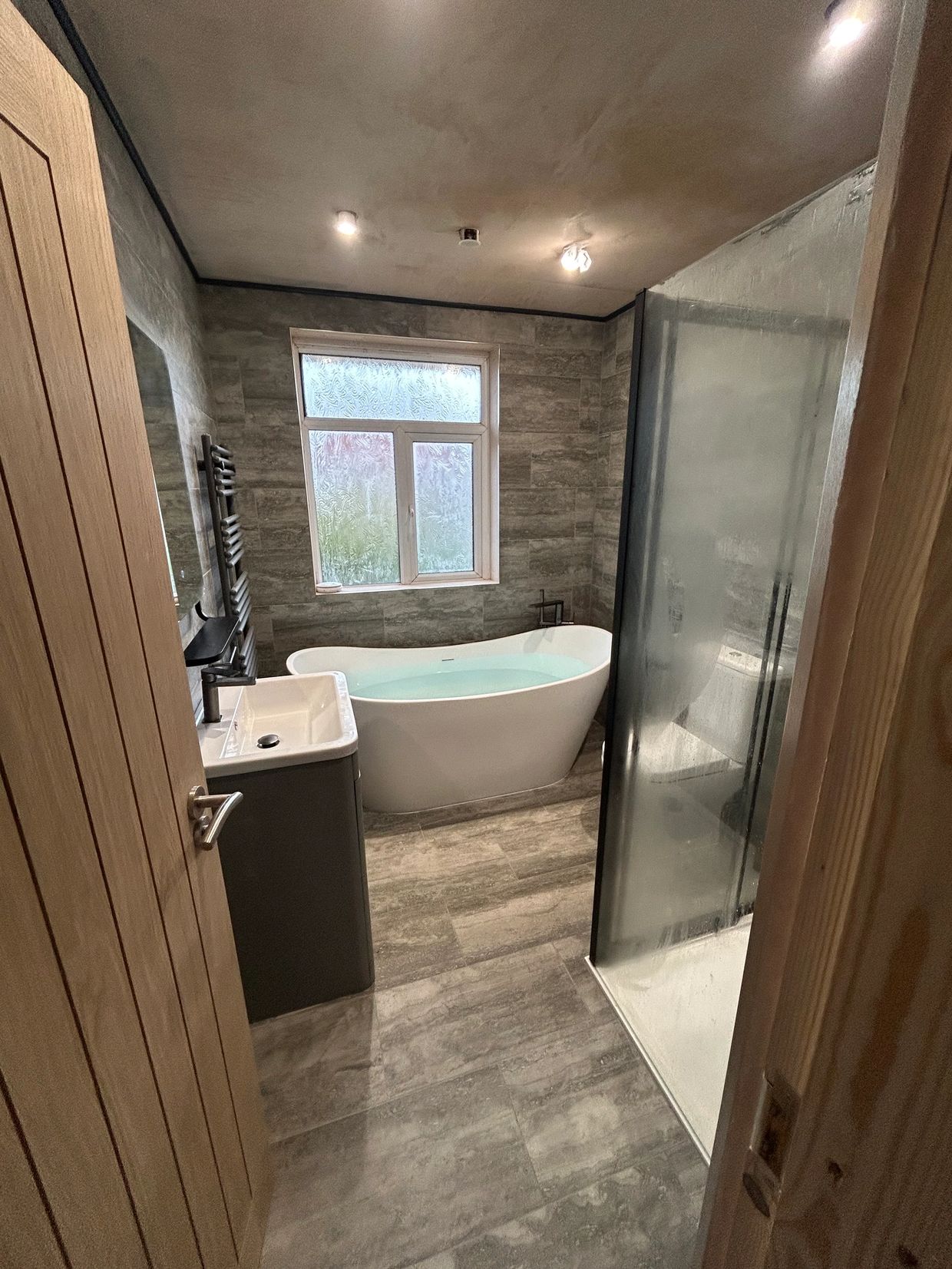 Modern bathroom with freestanding bathtub and walk-in shower.