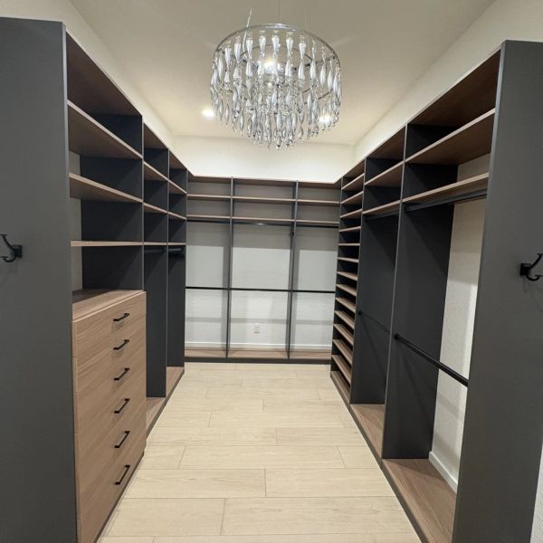 Empty modern walk-in closet with chandelier.