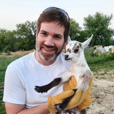 man holding a baby goat