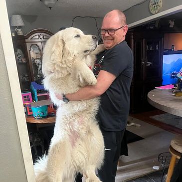 man holding a large white dog