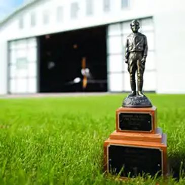 Trophy in front of an airplane hangar.