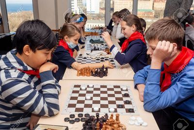 Children engaged in a chess tournament, concentrating on their games.