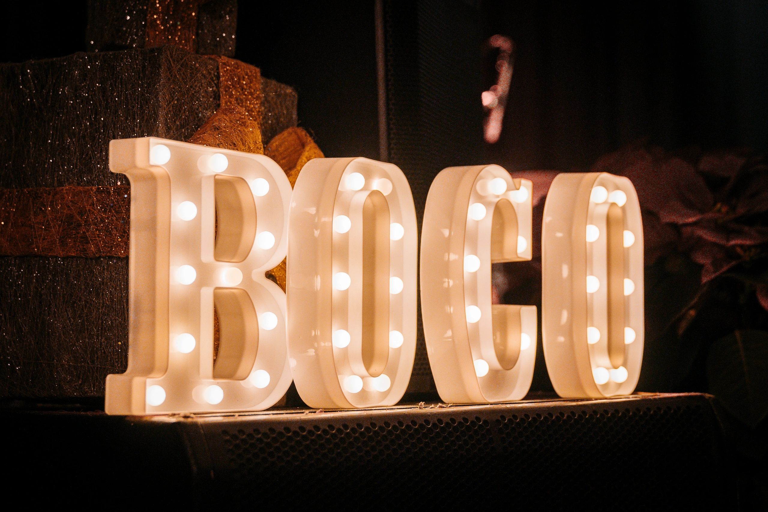 Illuminated letters spelling "BOGO" in warm light against a dark background.