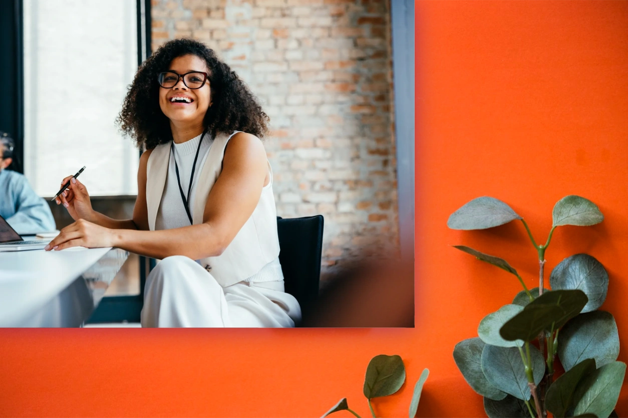 Woman smiling while working at her desk creating a strategy and operational strategic planning.