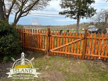 Stained fence with waterfront view.  