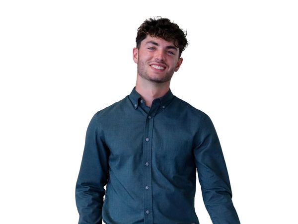 Smiling young man in a teal button-up shirt against a white background.