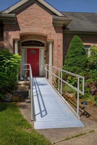 Ramp leading to a red front door of a brick house.