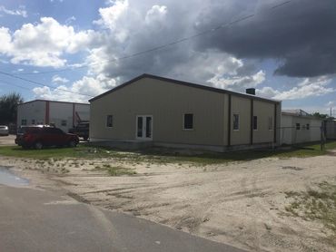 Finished grey metal building exterior in daylight.