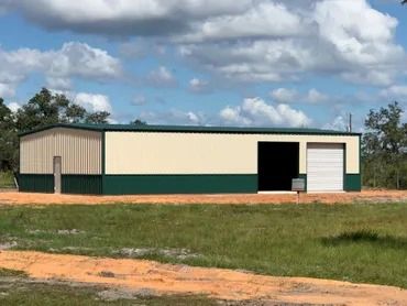 Beige and red metal warehouse under a blue sky.