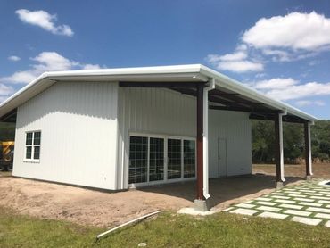 Open white metal building structure with exposed roof.