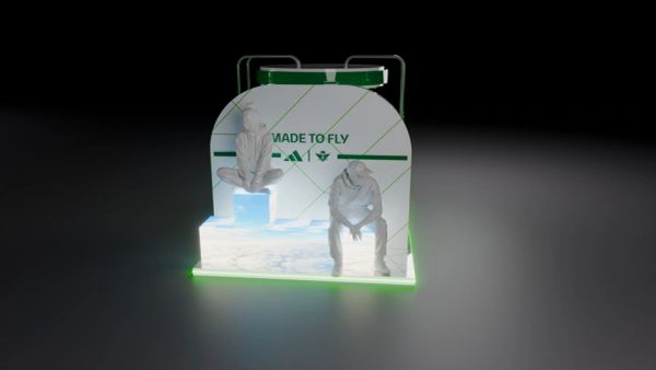 Two white statues on illuminated platform with 'MADE TO FLY' background.