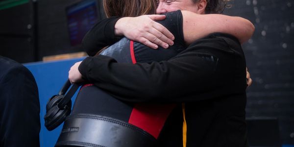 Coach and athlete hug after a successful lift 