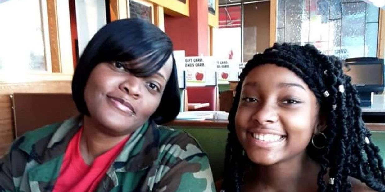 Two smiling women sitting together in a casual restaurant.