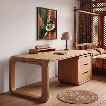 Modern wooden desk with curved design in a cozy bedroom corner.