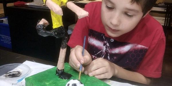 Child makes soccer art sculpture
