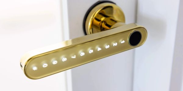 A gold smart door handle with illuminated numeric keypad.