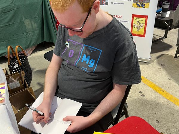 Liam signing a book at the markets