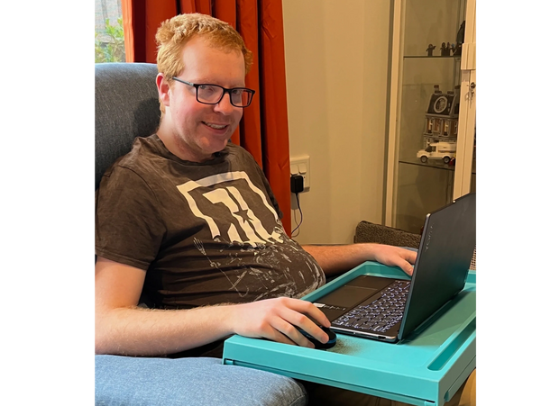 Liam writing with his laptop