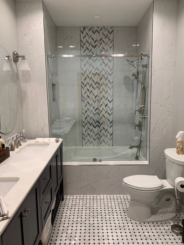 Kohler tub with Daltile tile on walls. 
Natural marble on the floor. 
Kohler toilet. 
Heated towel b