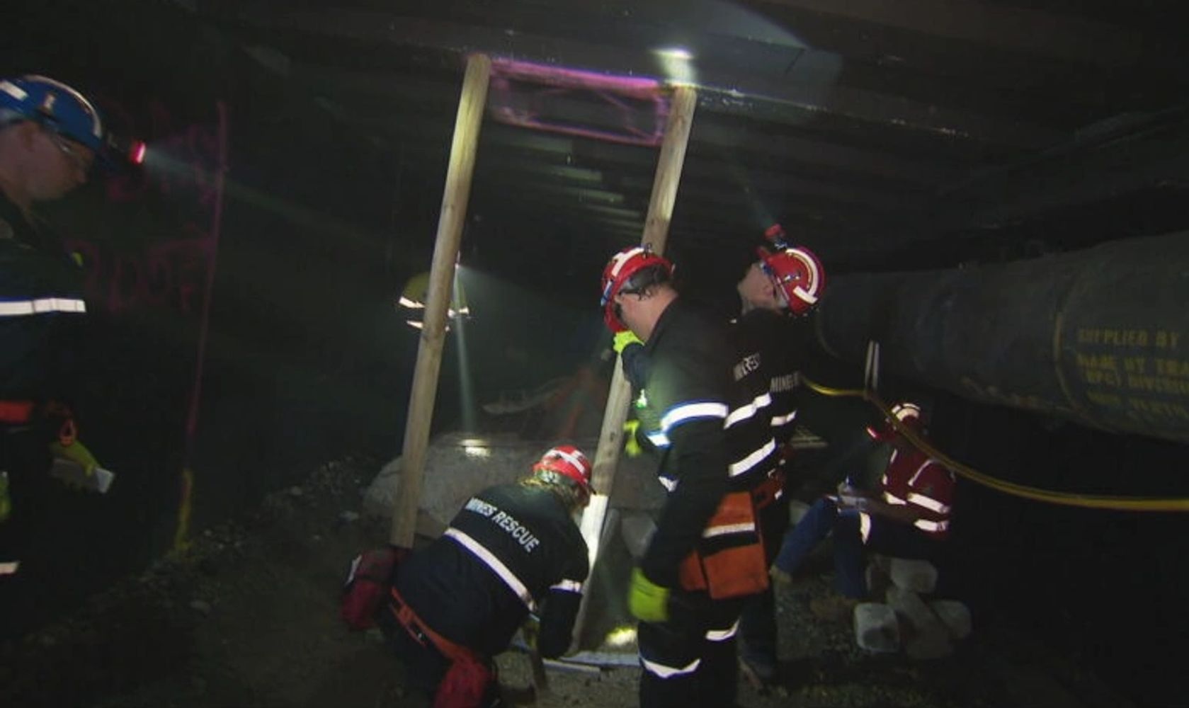 Rescue workers operating in a dark underground tunnel.