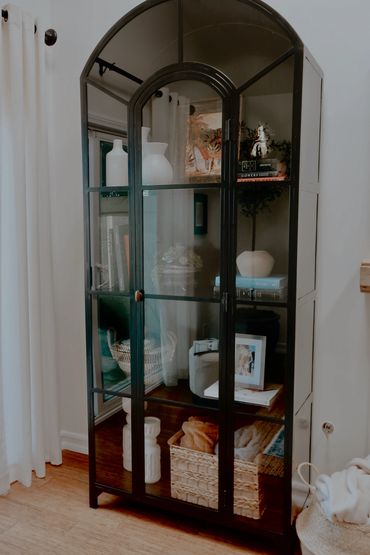 Beautiful arched top Darcie Cabinet by McGee and Co. sits well in this Spanish living room