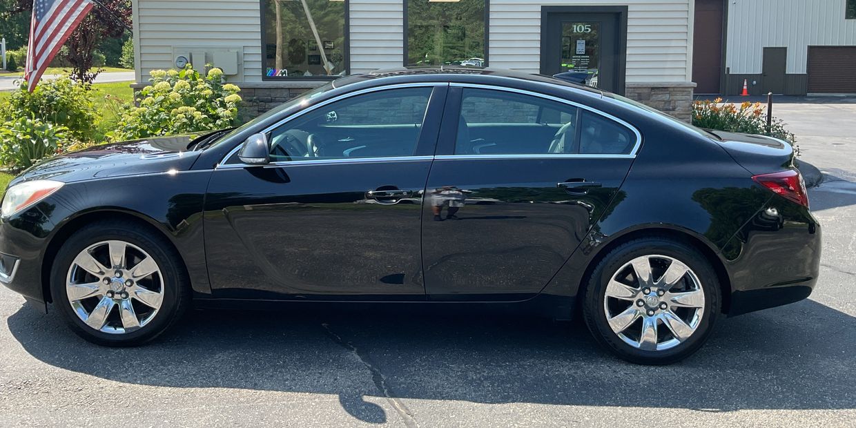 Black sedan parked outside a building.