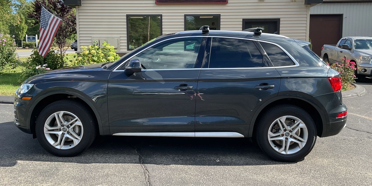 Side view of a dark gray Audi SUV parked.