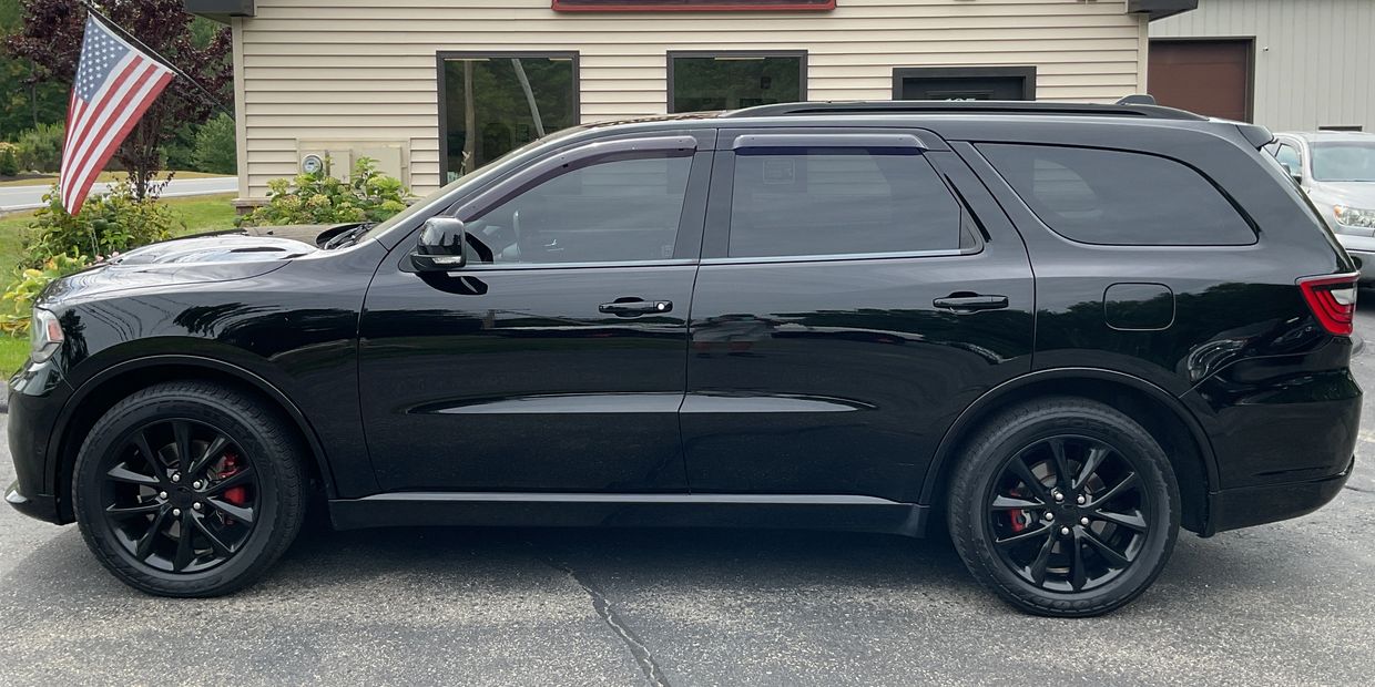 Sleek black SUV with tinted windows parked next to a building.