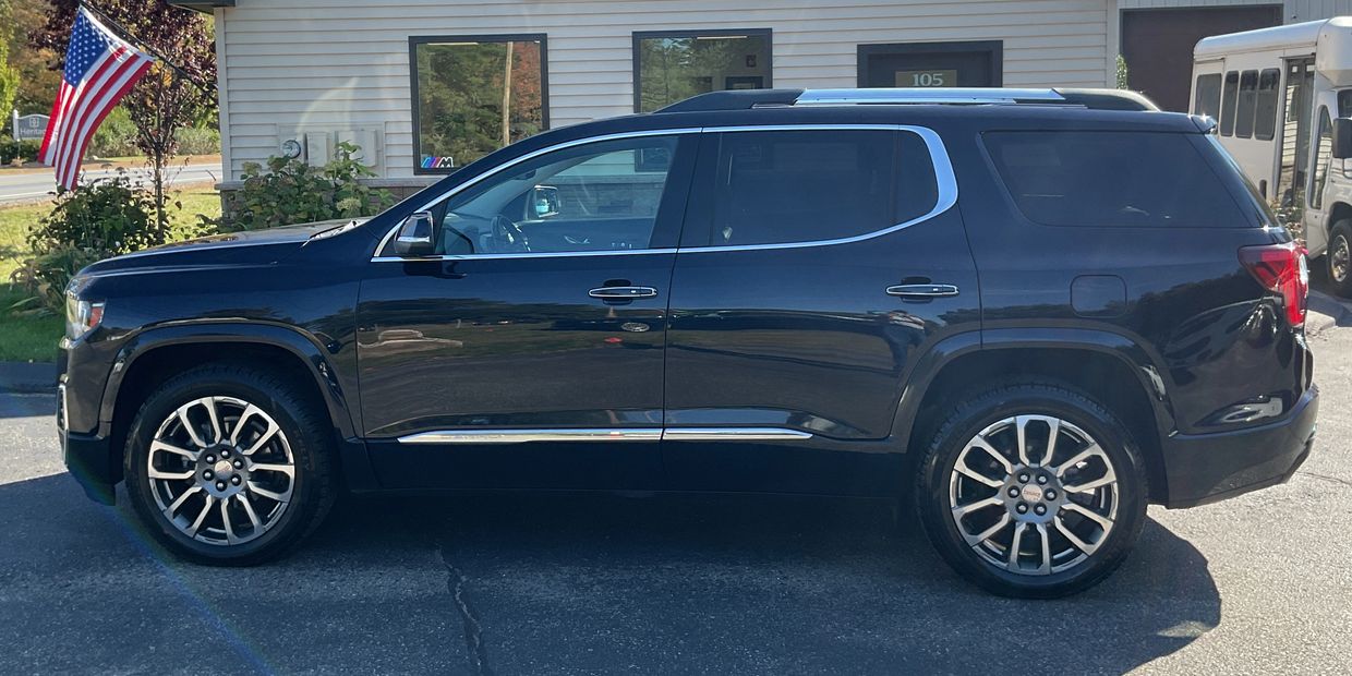 Black SUV parked in front of a building with an American flag.
