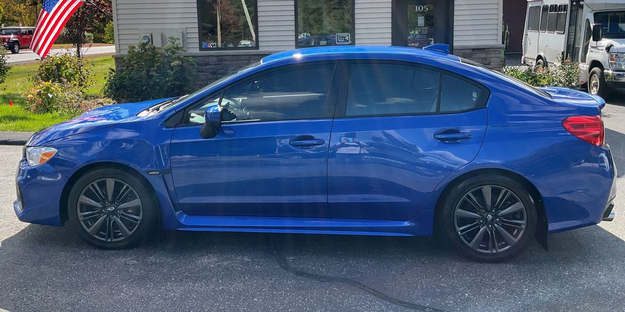 Blue Subaru WRX parked outside a building.