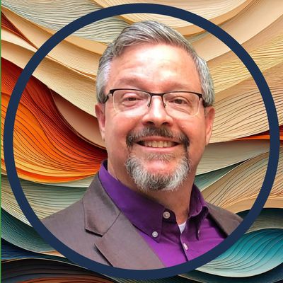 Smiling man with glasses and gray hair against a colorful abstract background.