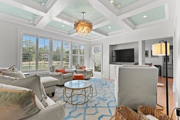 updated living room with coffered ceilings and lagoon view
