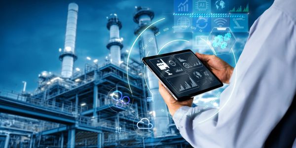 Engineer using tablet for industrial plant monitoring with AI data overlays.