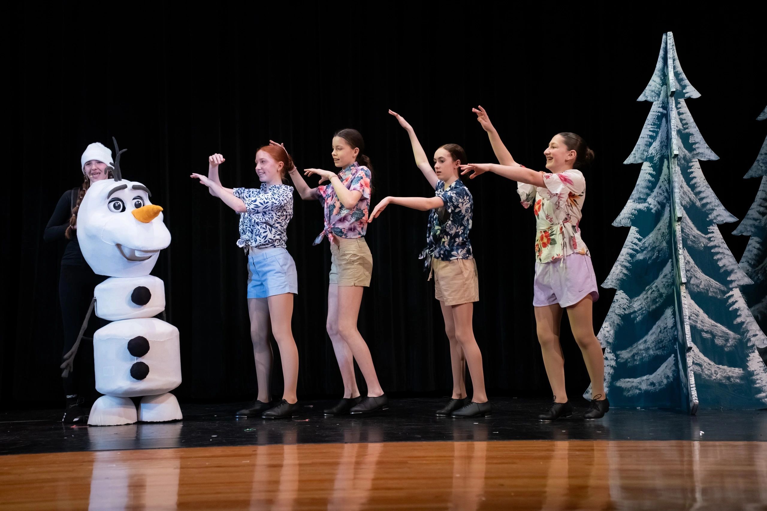 Dance performance with Olaf and a group of dancers in tropical outfits.