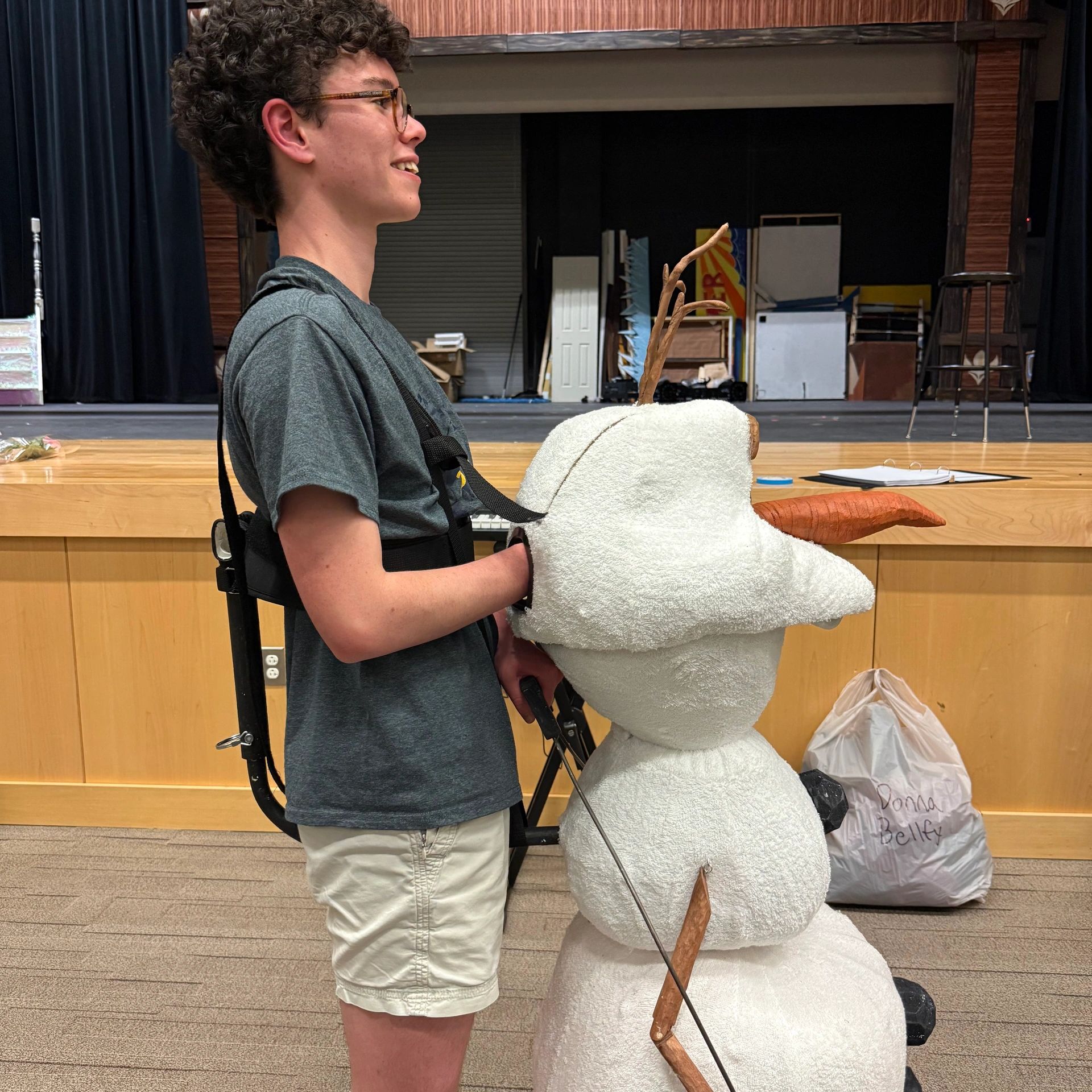 A young person wearing an Olaf costume with arms inside the snowman.