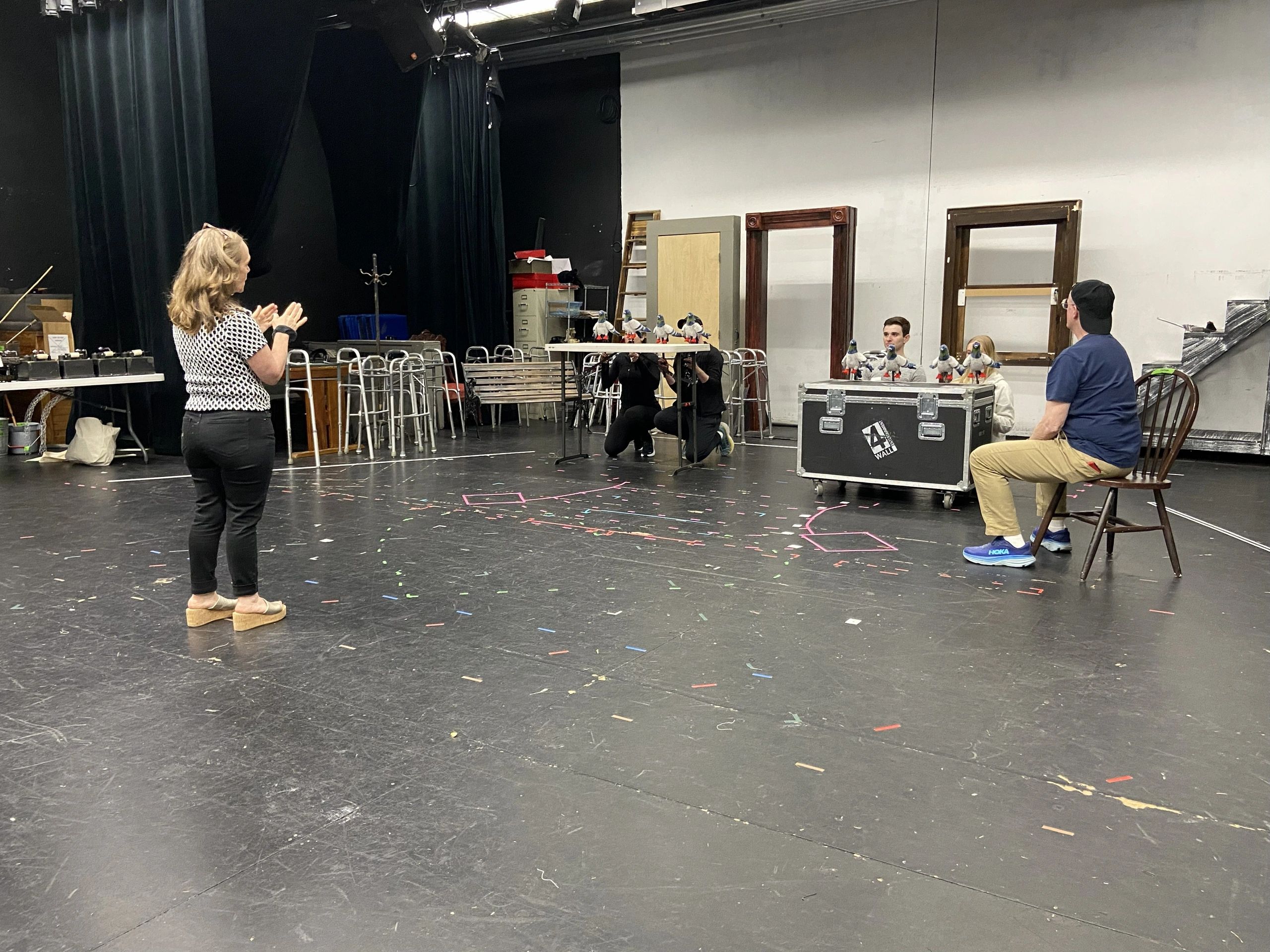 People rehearsing with puppets in a theater studio.