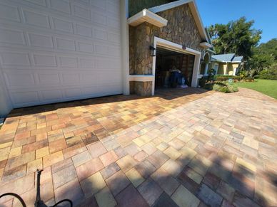 Newly paved driveway with multicolored bricks in front of a garage.