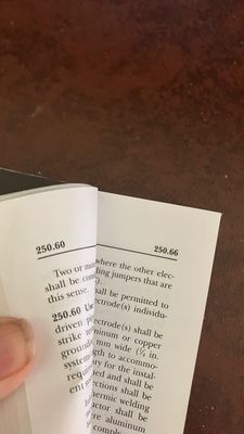 A close-up of a book open to pages 250 and 251 on a brown surface.