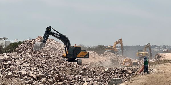Excavadoras con martillos hidráulicos rompiendo piedra para una zanja de 9 metros. 