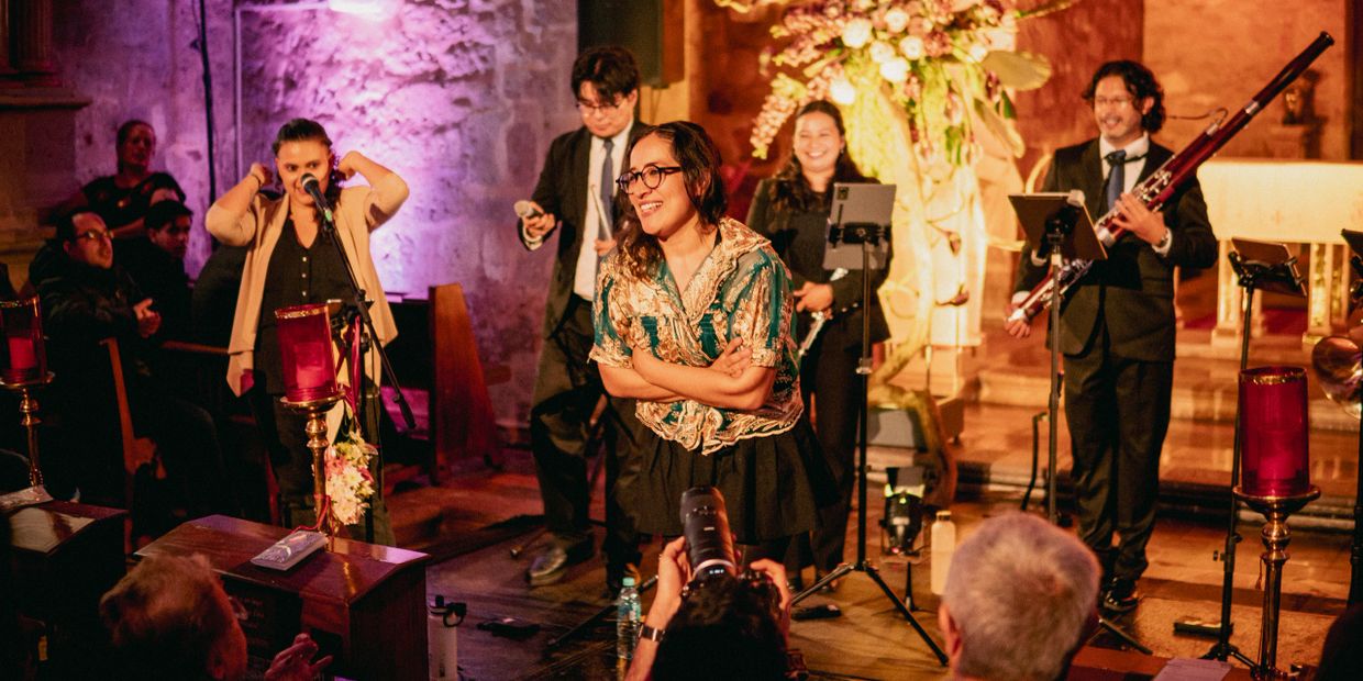 A joyful woman takes a bow on stage during a lively musical performance.
