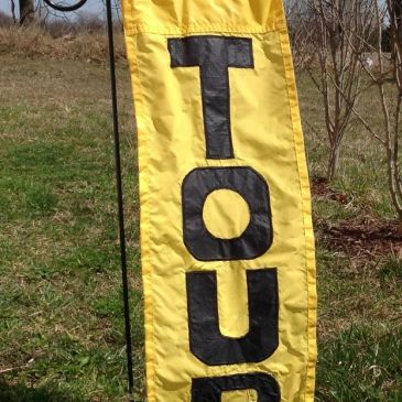 Yellow banner with black letters spelling 'TOU'.