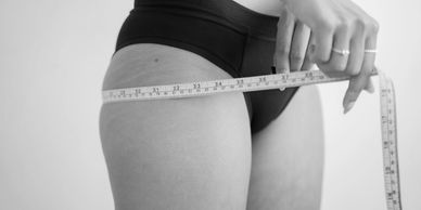 a woman measuring her size with a measuring tape 